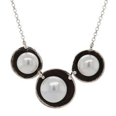 Necklace with three pearls in black circles on a white background