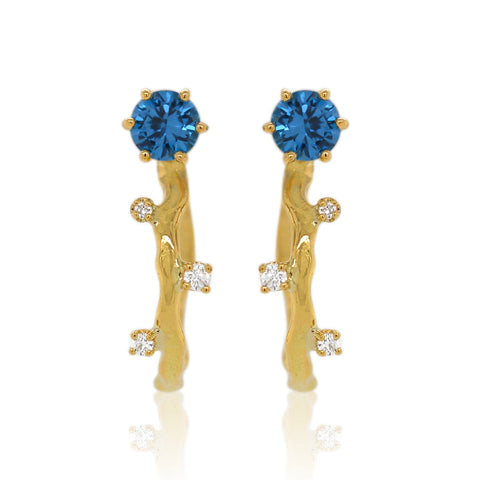 Gold earrings with blue gemstones on a white background